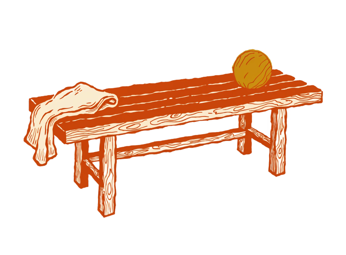 An empty dugout bench with a folded towel and a ball
